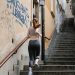 Back view of a female runner exercising on outdoor stairs in an urban setting.